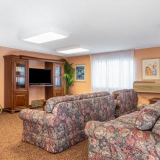 A cozy living room with patterned sofas, an entertainment center, and natural lighting.