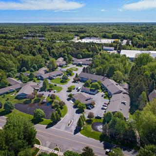 Aerial view of a suburban housing complex surrounded by trees.