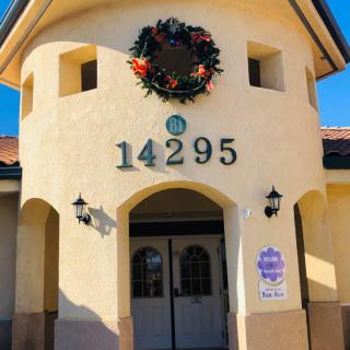 The entrance of a building with the address number 14295 adorned with a festive wreath.