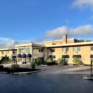 A view of a modern hotel exterior under a partly cloudy sky.