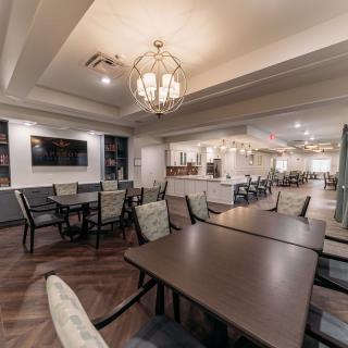 A modern dining area with elegant chandeliers, comfortable seating, and stylish decor.