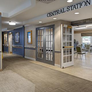 A well-decorated hallway leads to a central station area with glass doors and seating.