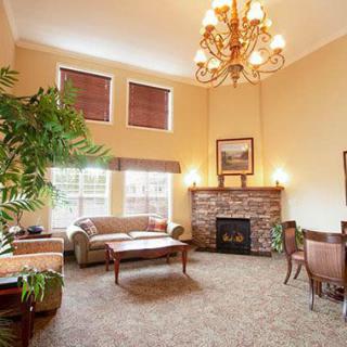 A cozy living room with elegant furnishings, featuring a chandelier and fireplace.