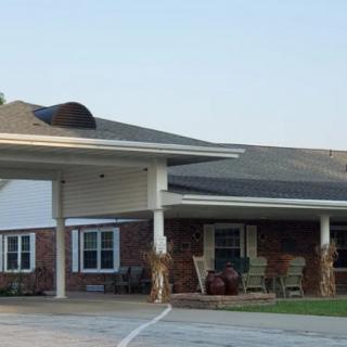 A residential building with a covered entrance and seating area.