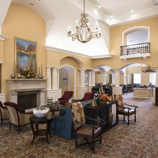 A luxurious lobby area featuring elegant seating, a grand chandelier, and a decorative fireplace.
