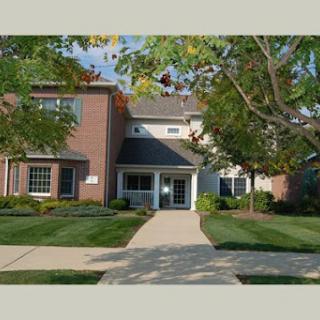 A well-maintained residential building surrounded by lush landscaping.
