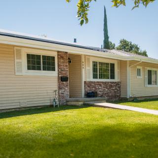 A suburban house with a well-kept lawn and brick accents.