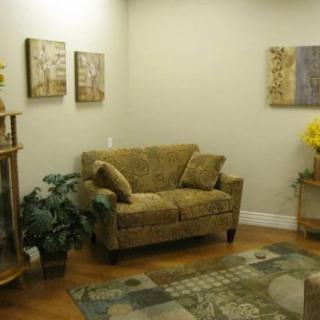 A cozy living room with a comfortable sofa, indoor plants, and decorative wall art.