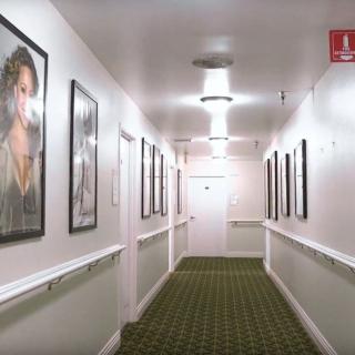 A well-lit hallway featuring framed artwork on the walls.