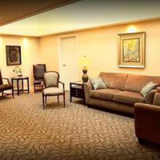 A cozy living room featuring a comfortable sofa, chairs, artwork on the walls, and soft lighting.