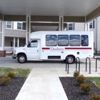 A white bus parked in front of a building.