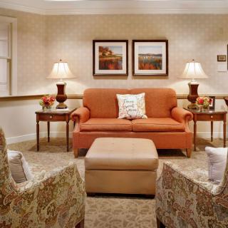 A cozy living room with a sofa, armchairs, and elegant lighting.