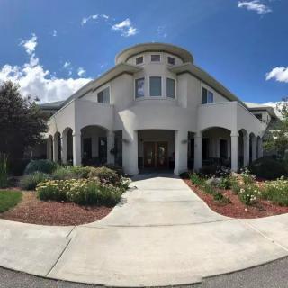 A beautifully designed building with a landscaped garden on a sunny day.