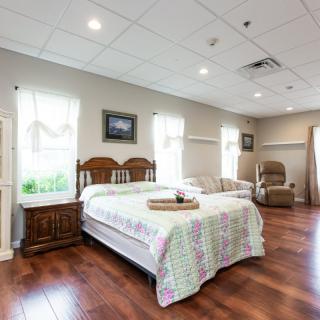 A cozy bedroom with a double bed, wooden flooring, and comfortable seating.