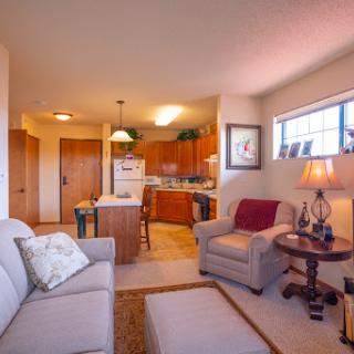 A cozy and modern apartment featuring a living area that opens up to a well-equipped kitchen.