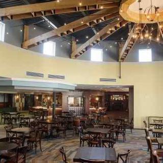 Interior view of a restaurant with tables and chairs arranged under a chandelier.