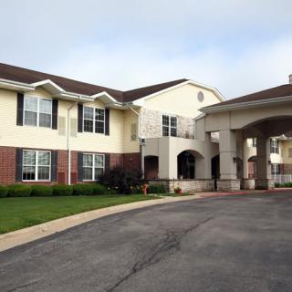 A two-story residential building with a driveway and entrance.