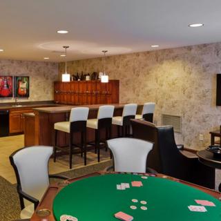 A stylish entertainment room featuring a bar and poker table, perfect for hosting games and social gatherings.
