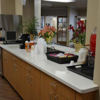 A well-organized kitchen counter featuring beverages and decorative flowers.