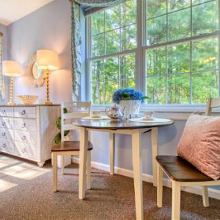 A cozy dining nook bathed in natural light, featuring a charming wooden table and a serene view of the outdoors.