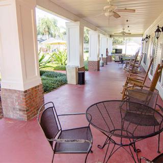 A spacious porch with outdoor seating and a garden view.