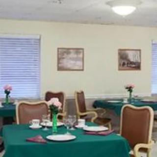 A dining room with neatly set tables, each adorned with flowers.