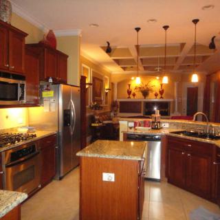 A modern kitchen with wood cabinets, stainless steel appliances, and an island.