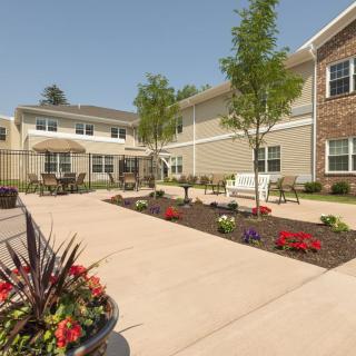 A well-maintained courtyard with flowers and seating area in front of a building.