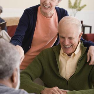 A group of seniors enjoying a friendly conversation indoors.