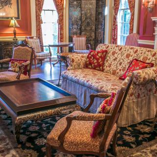 A luxurious vintage-style living room with antique furniture and floral patterns.