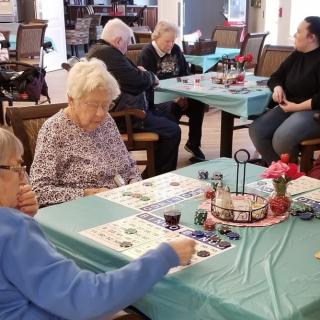 A group of seniors playing bingo together in a comfortable setting.