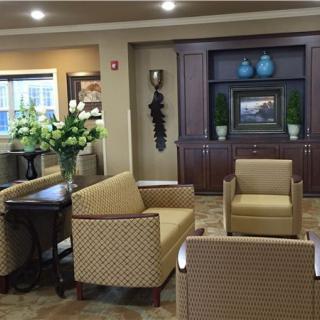 A cozy lobby with comfortable seating, floral arrangements, and decorative elements.