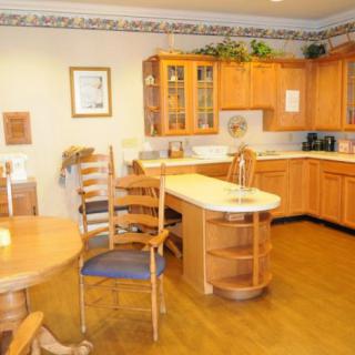 A kitchen with wooden cabinets and a dining area featuring a table and chairs.
