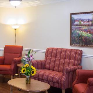 A cozy living room with red furniture and a decorative painting on the wall.