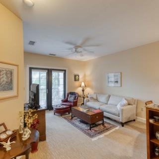 A cozy living room featuring a comfortable sofa, coffee table, and a ceiling fan, with artwork adorning the walls.