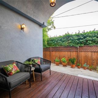 A cozy patio area with comfortable seating and a view of a small garden.
