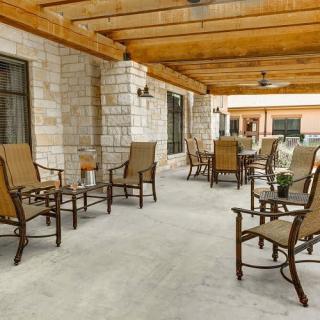 An inviting outdoor patio with comfortable seating and a wooden pergola.
