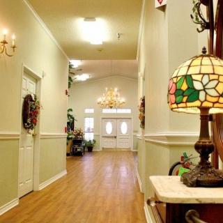 A warmly lit hallway with vintage decor and a colorful stained glass lamp.
