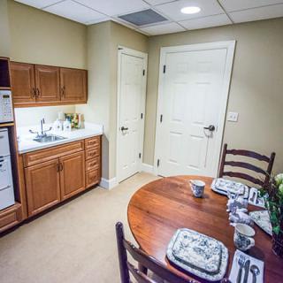 A cozy kitchen and dining area featuring wooden cabinets and a round dining table set for breakfast.