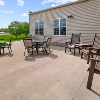 A spacious outdoor patio with seating and a table, perfect for relaxation on a sunny day.