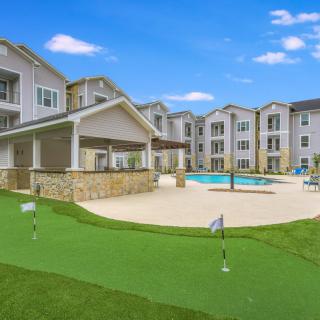 Modern apartment complex featuring a swimming pool and golf putting green.