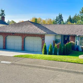 A single-story suburban house with a brick exterior and a three-car garage.