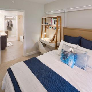 A modern bedroom with a cozy bed and a stylish desk setup.