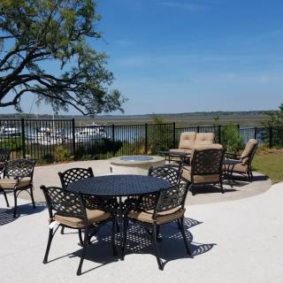 A scenic outdoor patio with a table and chairs overlooking a river.