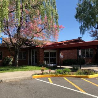 A sunny day showcasing a charming building surrounded by colorful trees.