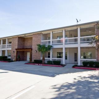 A two-story hotel building with parking spaces in front.
