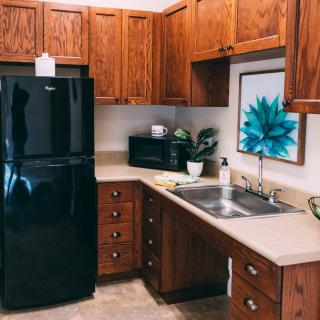 A cozy kitchen with wooden cabinets, a black refrigerator, and modern appliances.