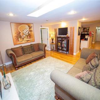 A cozy living room with sofas, a television, and artwork on the wall.