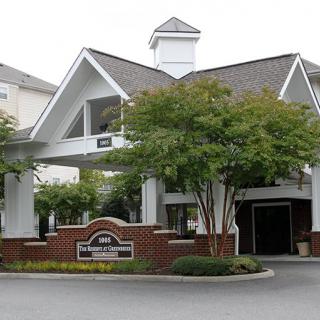 A hotel entrance with a landscaped garden and trees.
