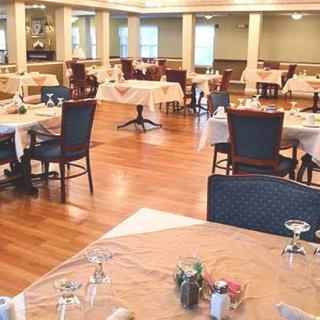 An empty restaurant dining room with elegantly set tables and chairs.